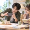 撮影スペースで商品をスマートフォンで撮り投稿を相談する男女
