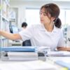 明るい記録管理室でパソコンに診療記録を入力する女性
